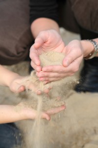 hands-of-adult-and-child-with-sand